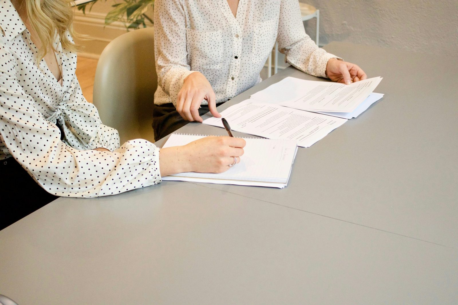 Two people working through documents together at a table